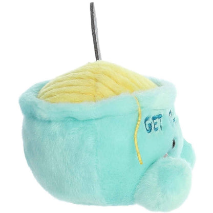 Side profile thumbnail of the mini soup bowl plush showcasing its rounded depth, upright gray spoon, and the side profile of the embroidered text.