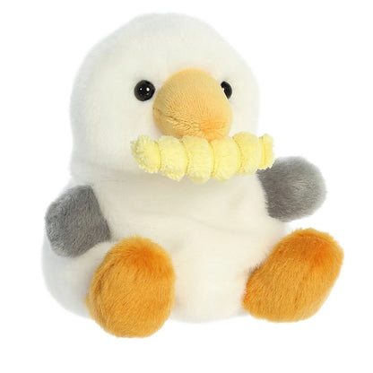 Aurora 5-inch Palm Pals Buoy Seagull with Fry plush toy showing its white body, gray wings, orange beak, and a yellow crinkle-cut french fry clamped in its mouth.