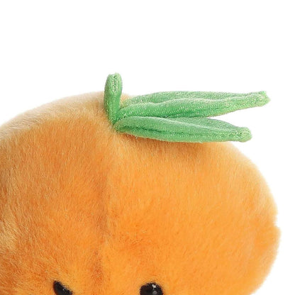 Close-up view of the Aurora Tangie Orange plush highlighting the two soft green leaves attached to the top of its head.