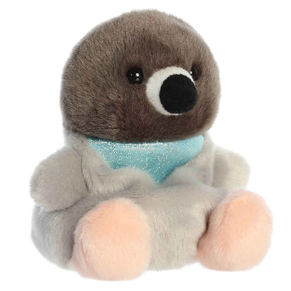 Aurora 5-inch Palm Pals Crumbs Pigeon plush toy sitting at an angle showing its brown head, light grey body, peach feet, and shimmery teal neck collar.
