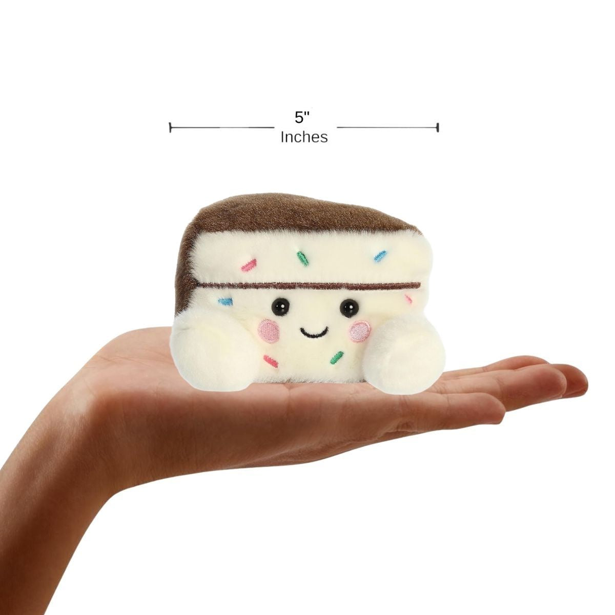 Dimension graphic showing the Aurora Palm Pals Sprinkles Cake Slice resting comfortably in a person's hand with a 5-inch width label.