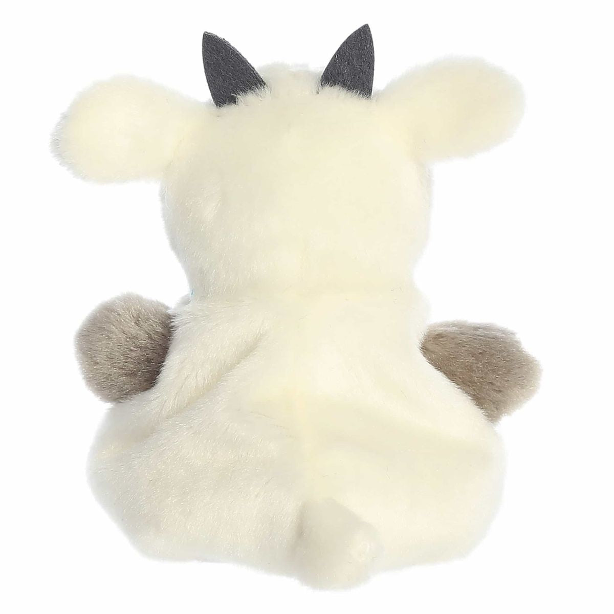 The rear view of the cream Aurora goat stuffed animal displaying its small floppy ears, back posture, and tiny tail.