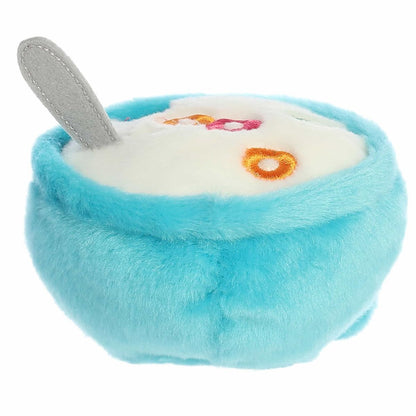 An overhead angled view of the cereal plush showcasing the embroidered colorful cereal loop pieces inside the white plush milk.
