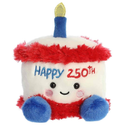 Straight-on front view of the soft white Palm Pals birthday cake stuffed animal with fluffy red trim and blue feet.
