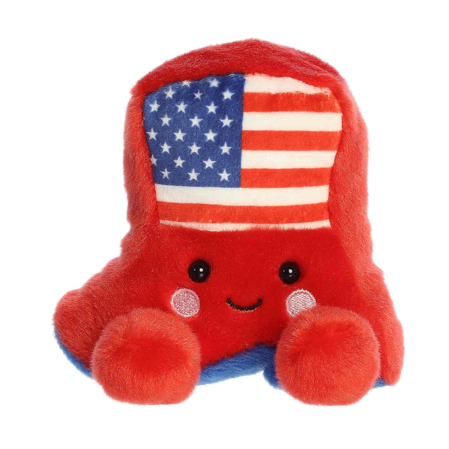 Straight front sitting view of the red cowboy boot plush showing its flag design, rosy cheeks, and plush little feet.