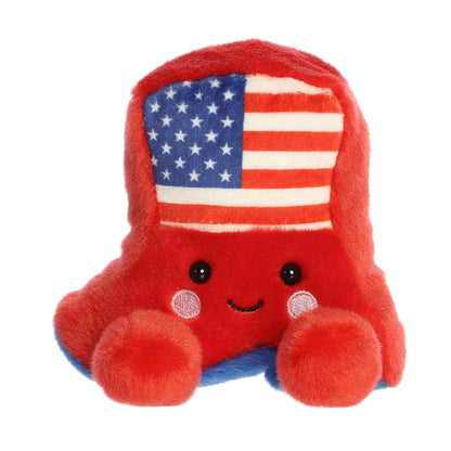 Straight front sitting view of the red cowboy boot plush showing its flag design, rosy cheeks, and plush little feet.