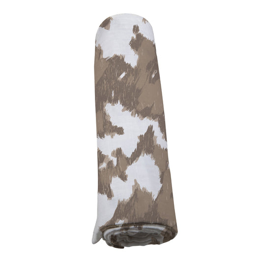 Straight view of the brown and white cowhide print bamboo muslin swaddle blanket neatly rolled up.