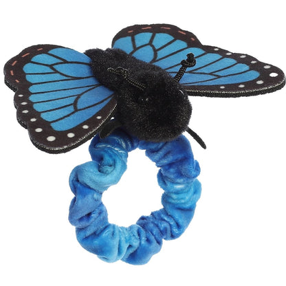 Angled view of the wearable Blue Morpho butterfly plush showing its fluffy black body and outstretched blue fabric wings.
