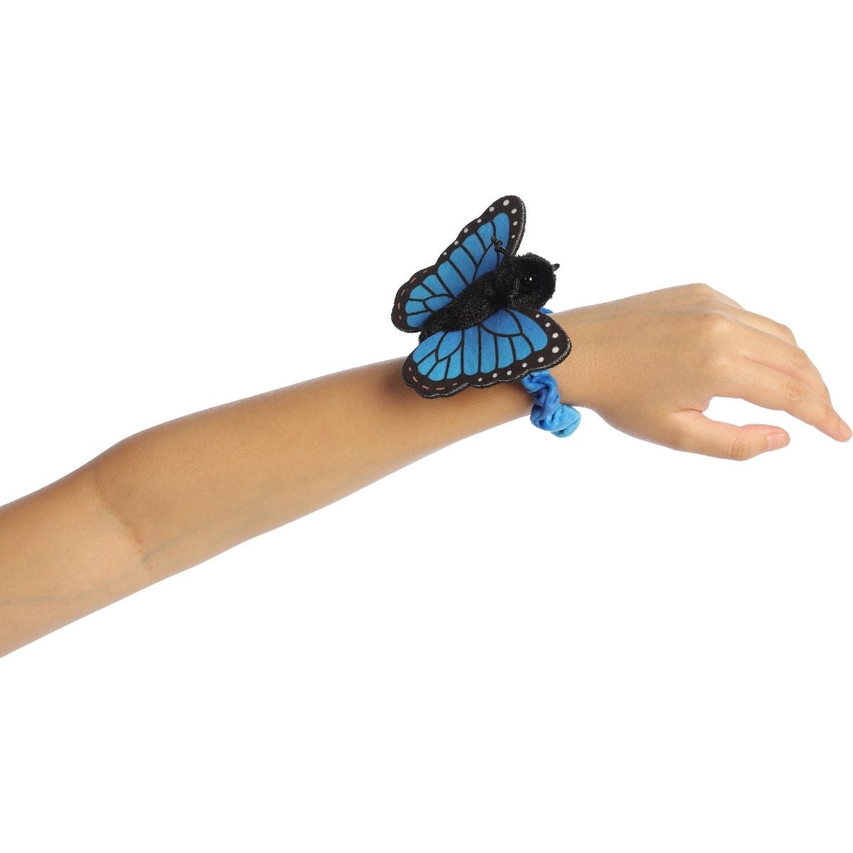 A child's arm outstretched, wearing the vibrant blue and black butterfly plush securely on their wrist.