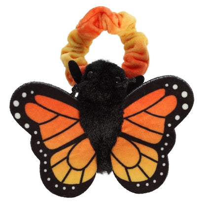 Top-down view of the orange and black Monarch butterfly resting flat against its orange tie-dye scrunchie wristband.