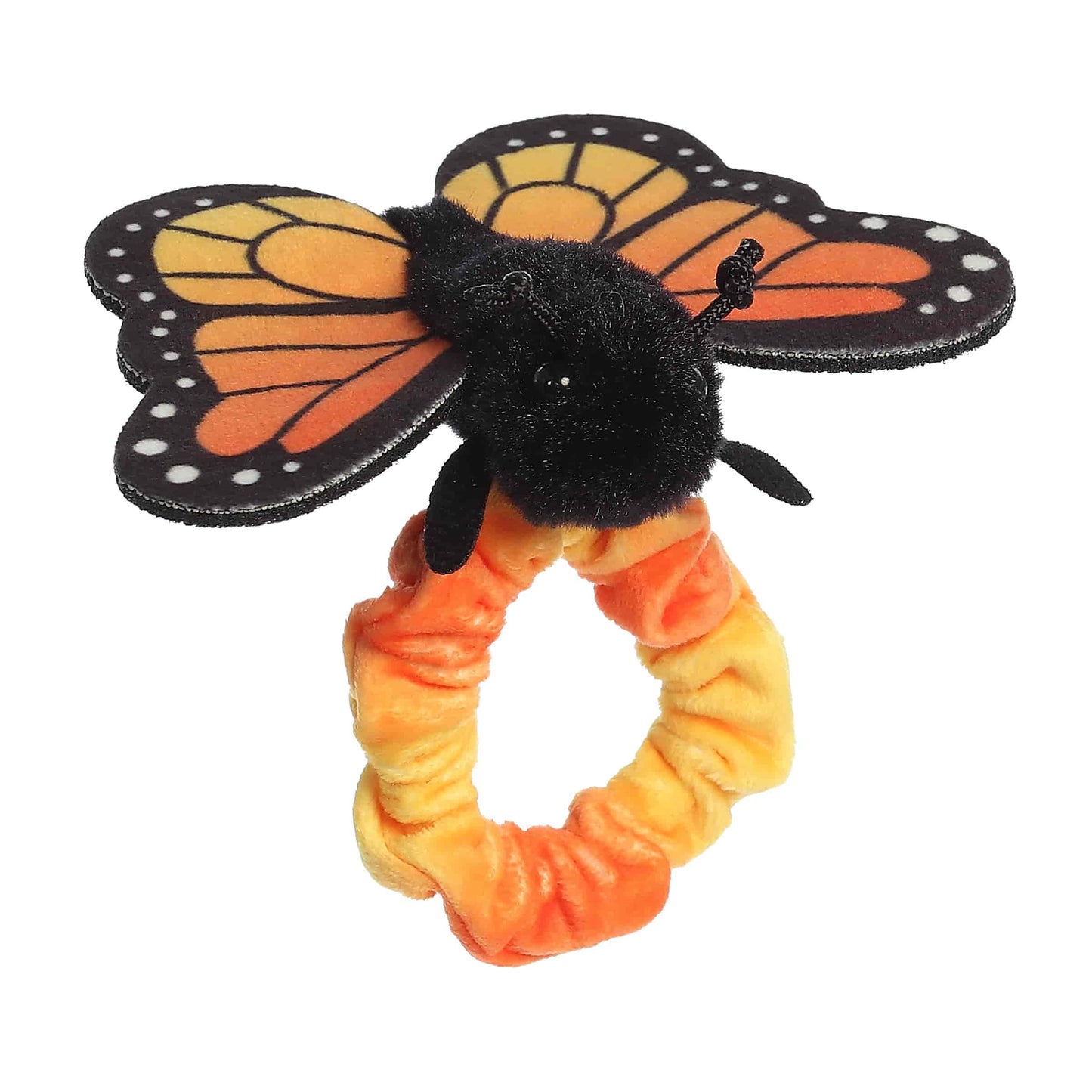 Angled side view of the wearable Monarch plush showing its fluffy black body and outstretched fabric wings.