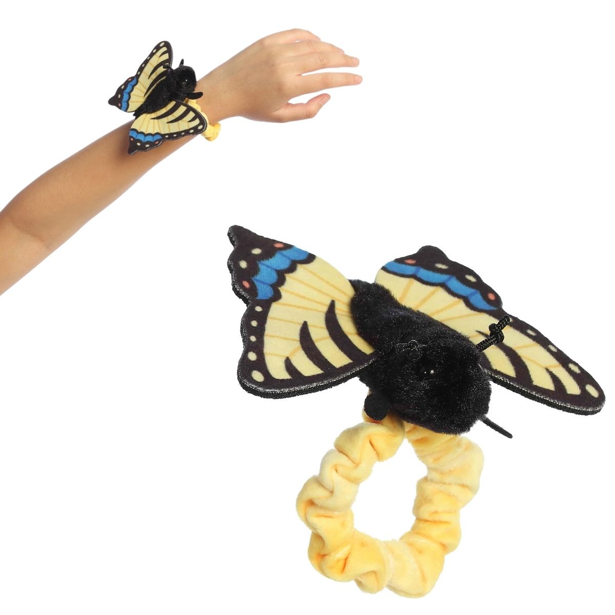 A person's arm wearing the 5-inch Aurora Wrist Flingers Tiger Swallowtail Butterfly plush alongside a close-up of the yellow and black butterfly on its wristband.