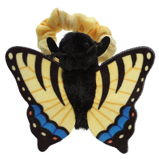 Top-down view of the yellow and black butterfly resting flat against its pale yellow scrunchie-style wristband.