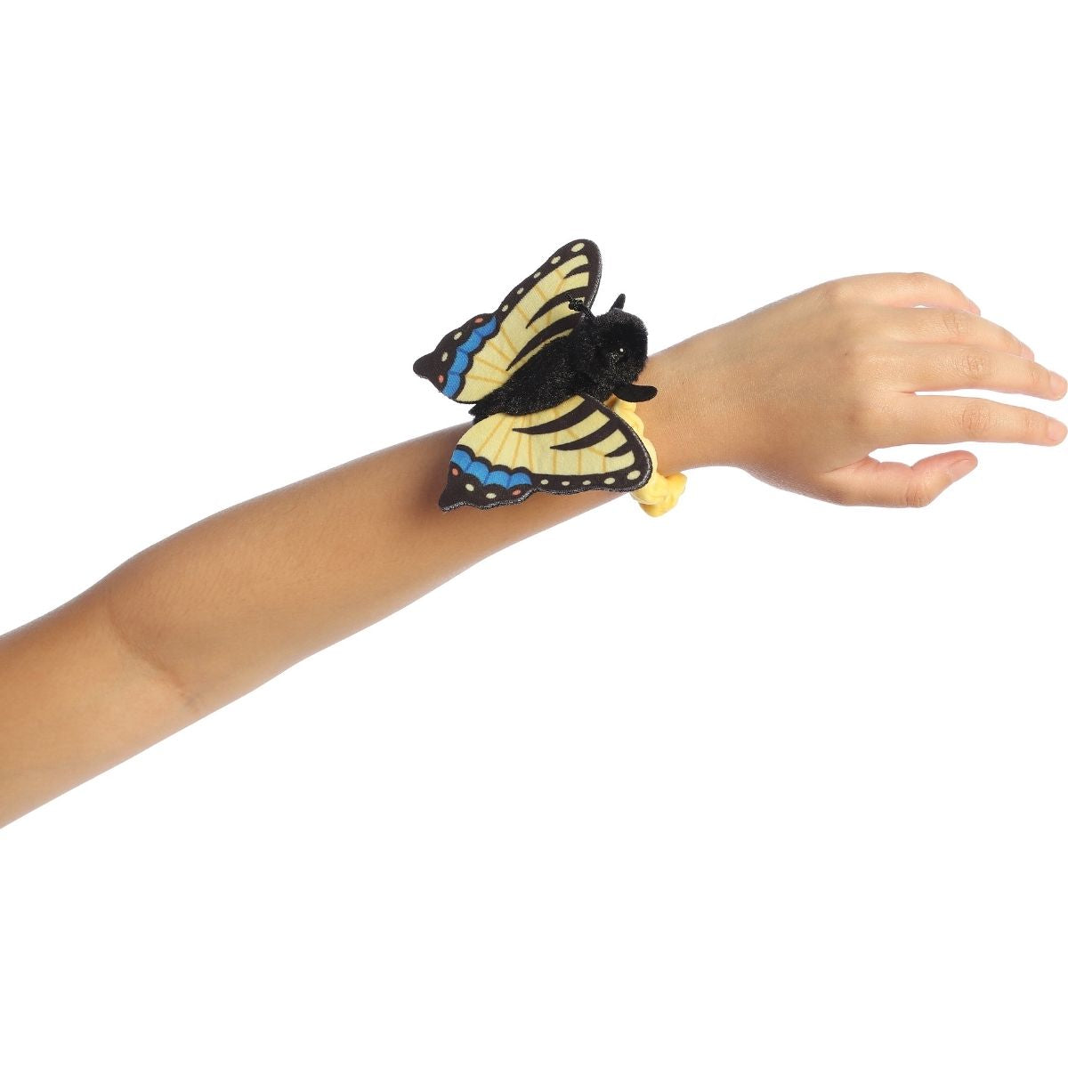 A child's arm outstretched, wearing the yellow and black butterfly plush securely on their wrist.