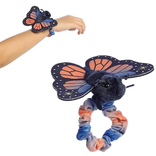 A person's arm wearing the 5-inch Aurora Wrist Flingers Sunset Butterfly plush alongside a close-up of the orange and blue butterfly on its wristband.