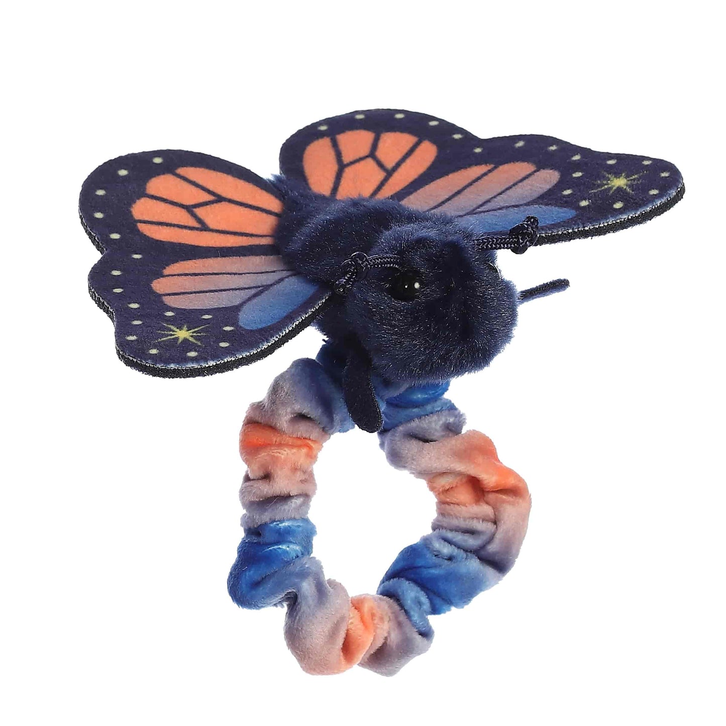 Side profile view of the wearable butterfly plush showing its fluffy dark body and outstretched sunset-colored fabric wings.