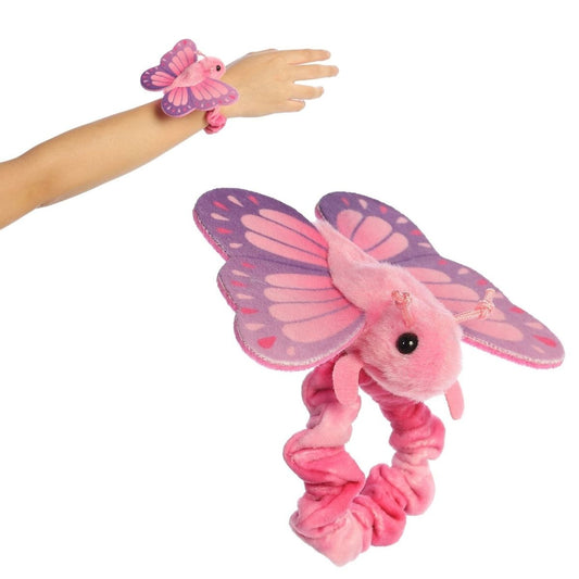A person's arm wearing the 5-inch Aurora Wrist Flingers Blush Butterfly plush with a close-up of the pink butterfly attached to its wristband.