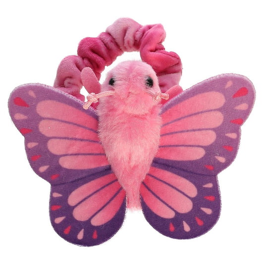 Top-down view of the pink and purple plush butterfly resting flat against its pink scrunchie-style wristband.