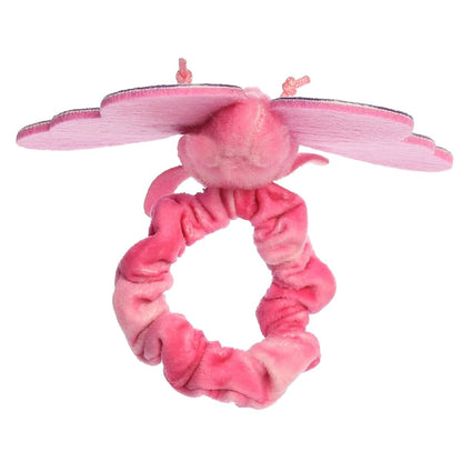 A child's arm outstretched, wearing the pink butterfly plush securely on their wrist like a bracelet.