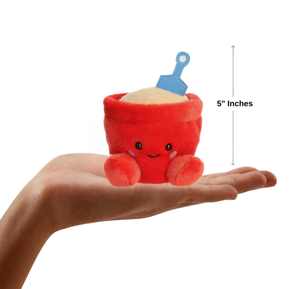 A hand holding the Aurora Palm Pals June Sand Bucket plush, demonstrating its small, 5-inch palm-sized design.