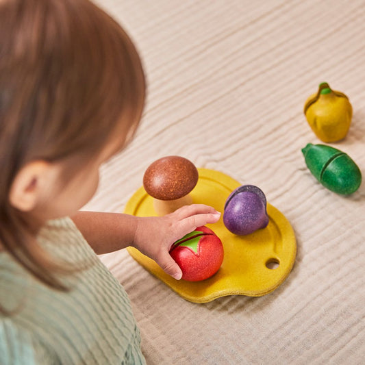 The PlanToys wooden assorted vegetables set featuring a cutting board, wooden knife, and sliceable toy food.