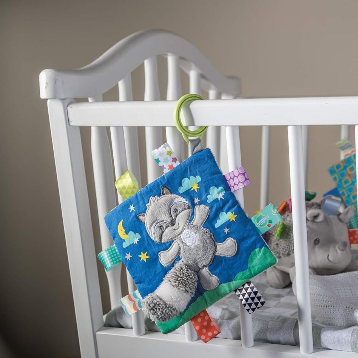 Bright patterned fabric and embroidered raccoon face on the Taggies activity toy.
