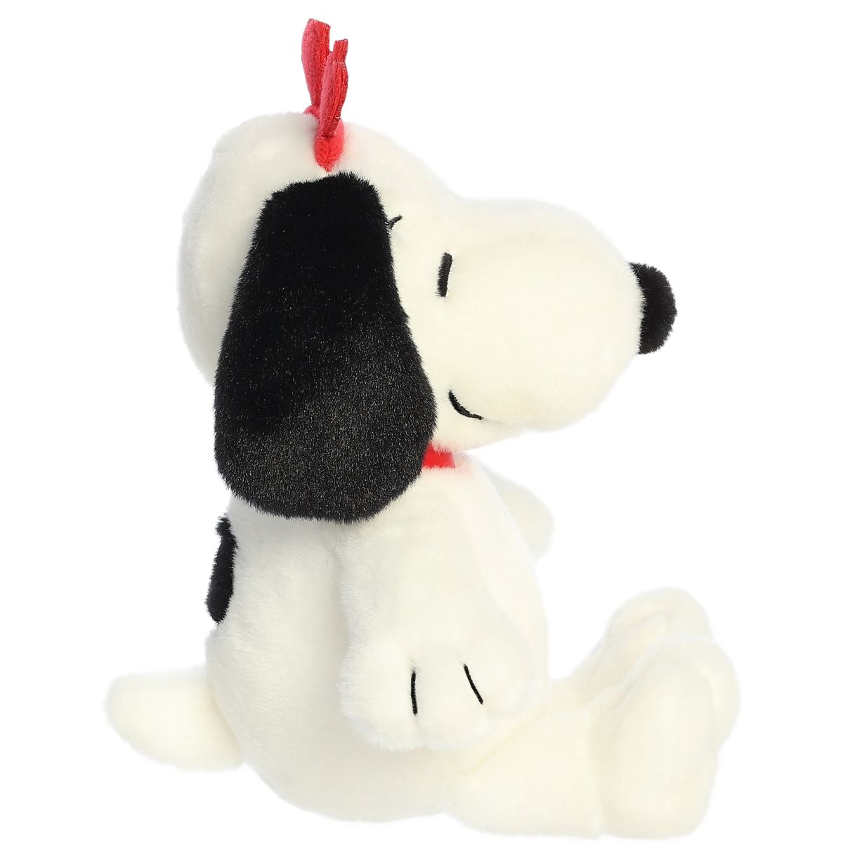 Side profile view of the Snoopy plush highlighting his sitting pose, red collar, and the side of his floppy black ear.