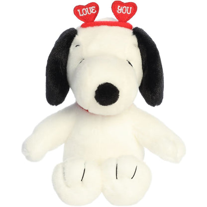 Front view of the Aurora 9-inch Peanuts Snoopy plush sitting upright, wearing his red collar and a red heart headband.