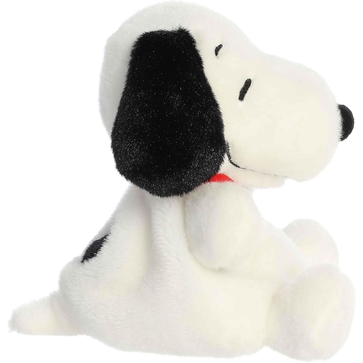 Side profile view of the Palm Pals Snoopy plush highlighting his perfectly squishy sitting pose and the side of his black ear.