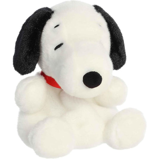 Angled view of the Aurora Palm Pals 5-inch Peanuts Snoopy plush sitting upright, showing his white fur, black ears, and red collar.