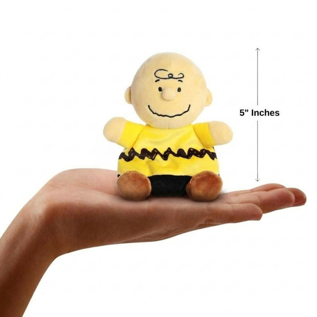 The miniature Peanuts Charlie Brown plush sitting balanced in an open human hand under a 5-inch height graphic indicator.