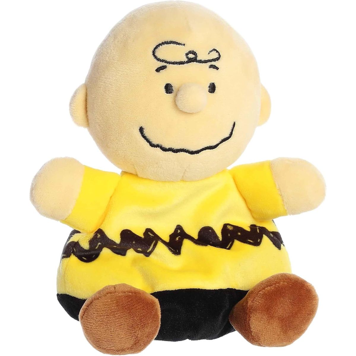 Aurora 5-inch Palm Pals Peanuts Charlie Brown plush toy sitting forward showing his iconic yellow polo shirt with the black zig-zag stripe and a happy stitched smile.