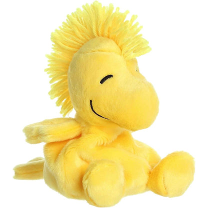 Aurora 5-inch Palm Pals Peanuts Woodstock plush toy sitting at an angle showing its bright yellow body, signature spiky head feathers, and happy stitched face.