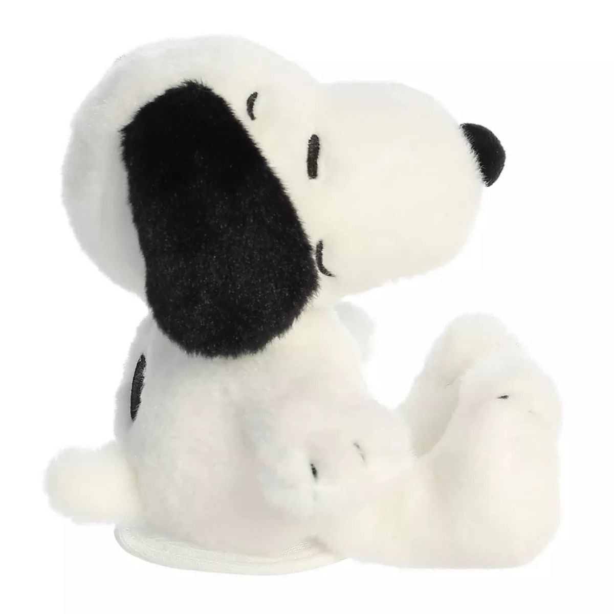 Side profile view of the cuddly Snoopy plush sitting comfortably.