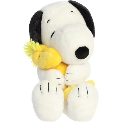 Straight-on front view of the soft Snoopy plush sitting upright with his eyes closed, hugging a yellow Woodstock plush.