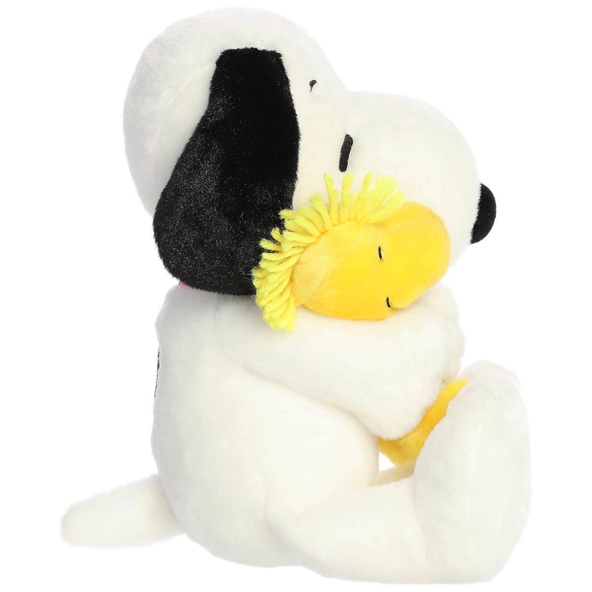 Side profile view of the cuddly Snoopy plush sitting comfortably, highlighting Woodstock's fluffy yellow feathers.