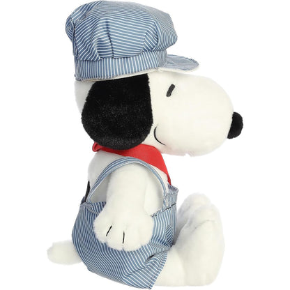 Side profile view of the cuddly Snoopy plush sitting comfortably, highlighting his red bandana and striped engineer hat.