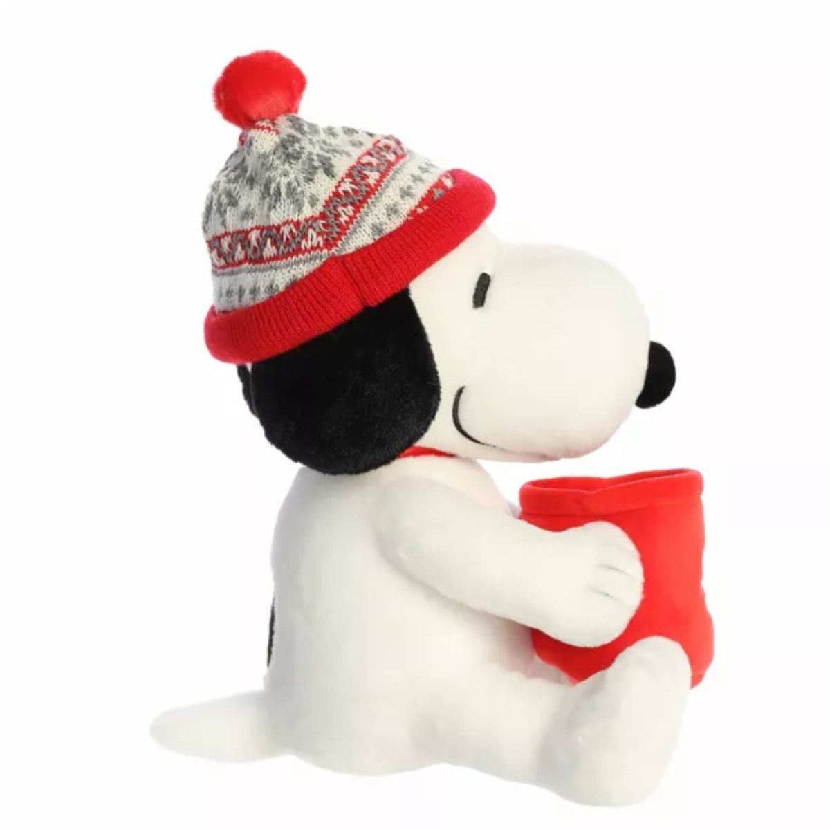 Side profile view thumbnail of the winter Snoopy plush showcasing his beanie hat, arm wrapped around the red mug, black back spot, and short tail.
