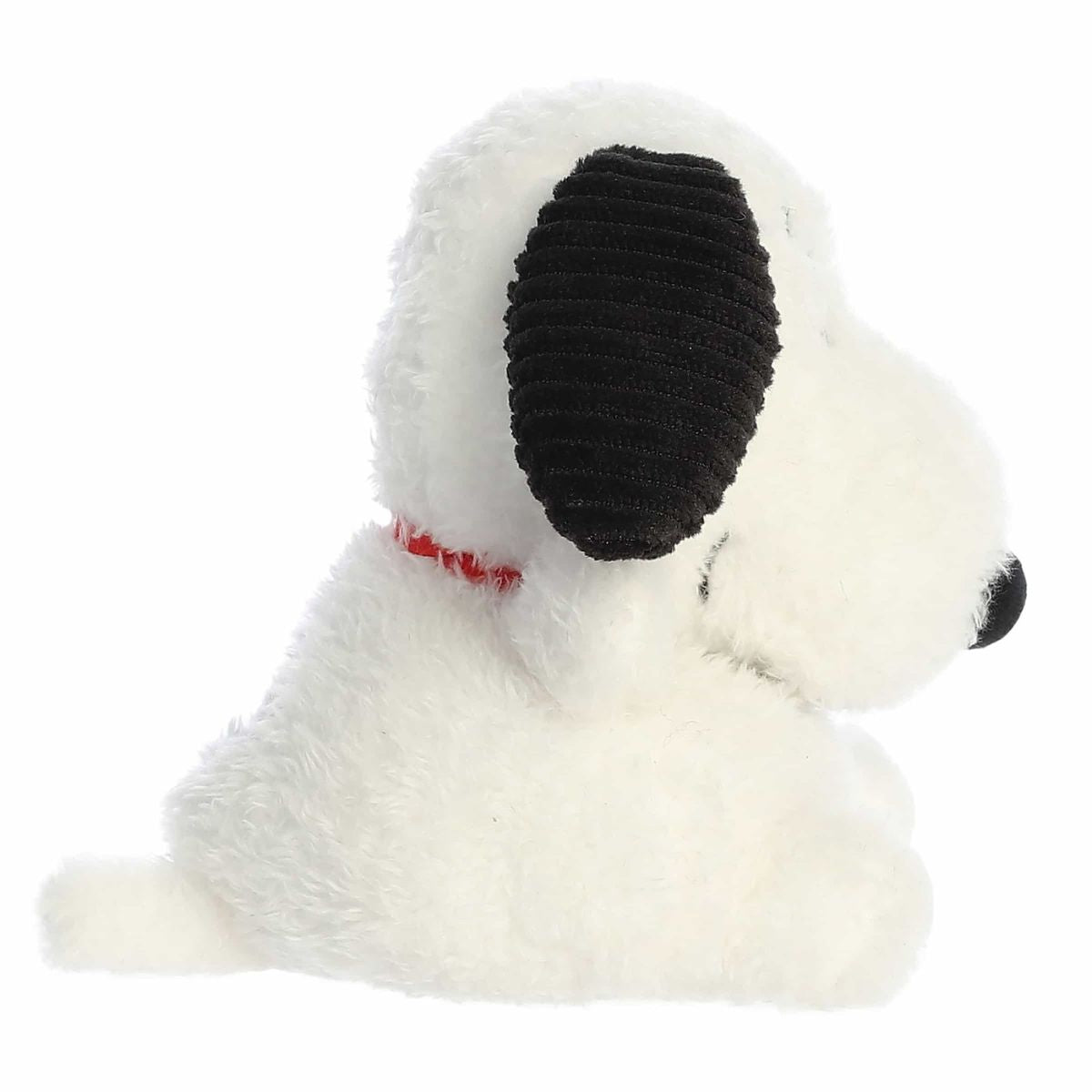 Side profile view of the palm-sized Snoopy plush showing his seated posture, fluffy tail, and red collar.