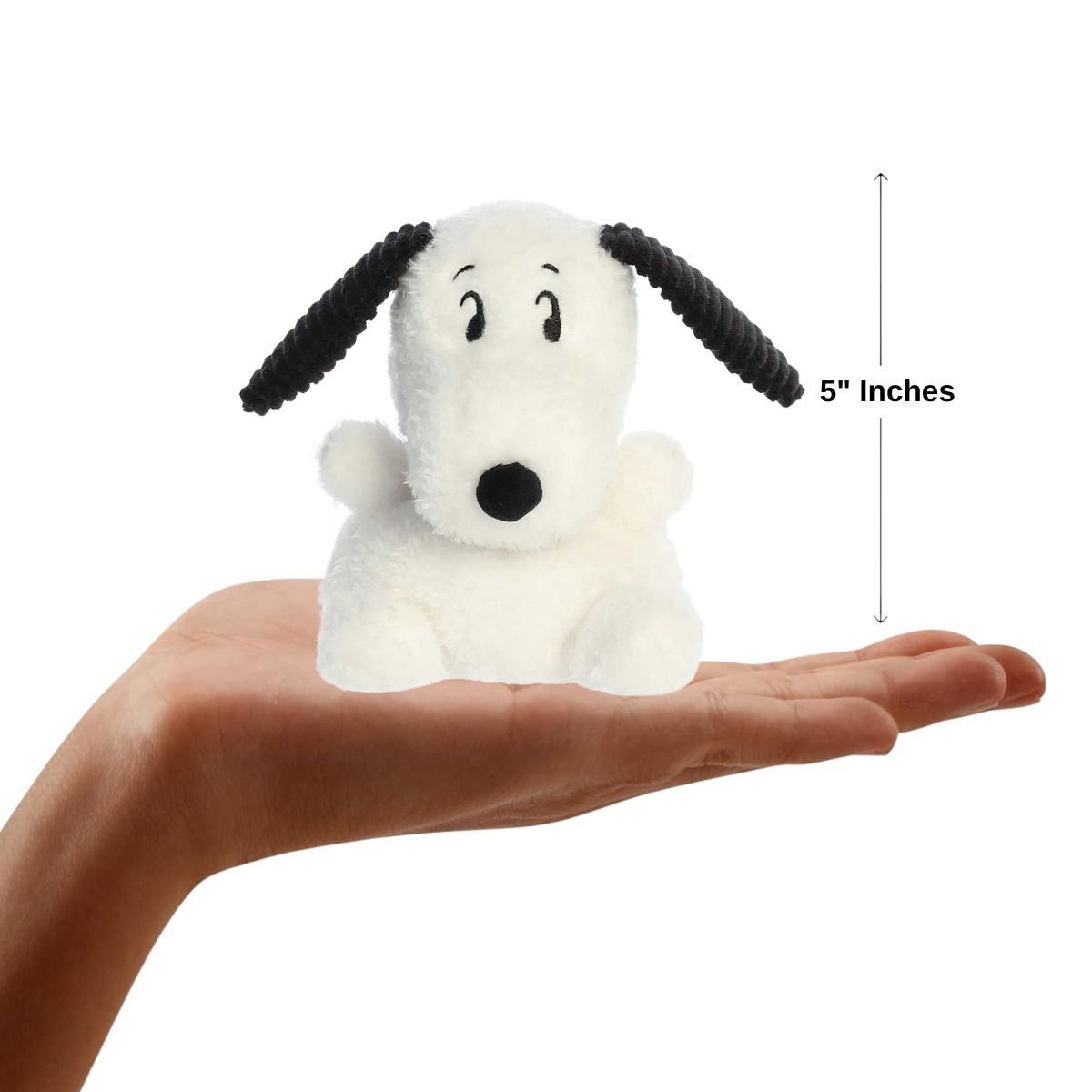 A hand holding the Aurora Palm Pals Snoopy plush, demonstrating its small, 5-inch palm-sized design.