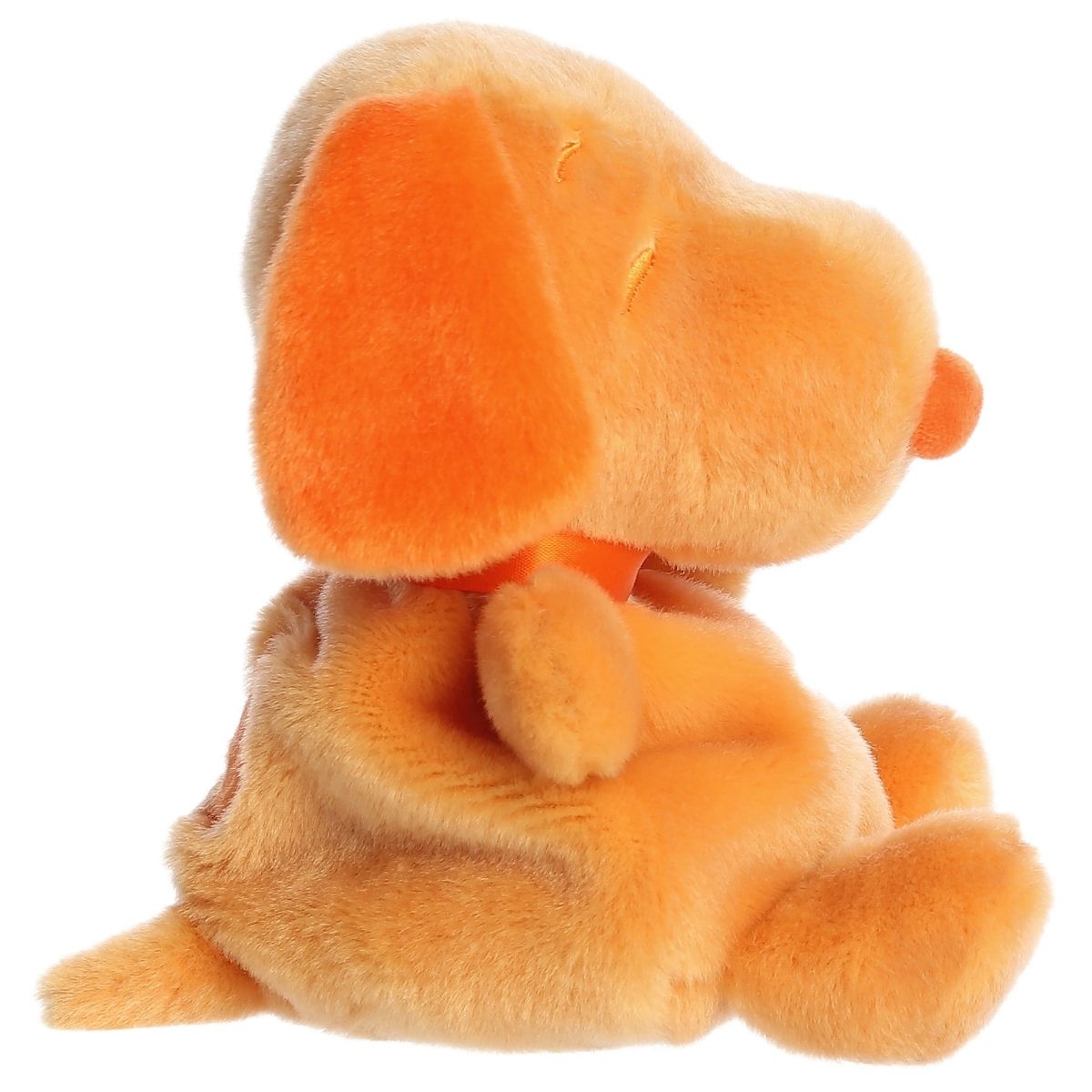 Side profile view of the Palm Pals Snoopy highlighting his plump shape, bright orange floppy ear, and back spot.