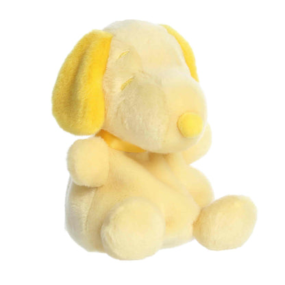 Front angled view of the 5-inch Aurora Palm Pals Peanuts Snoopy Color Collection plush toy featuring a pale yellow body with bright yellow ears and nose.