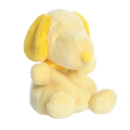 Front angled view of the 5-inch Aurora Palm Pals Peanuts Snoopy Color Collection plush toy featuring a pale yellow body with bright yellow ears and nose.