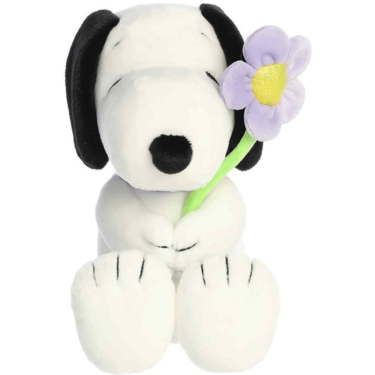Straight-on front view of the soft Snoopy plush sitting upright with a purple flower and collar.