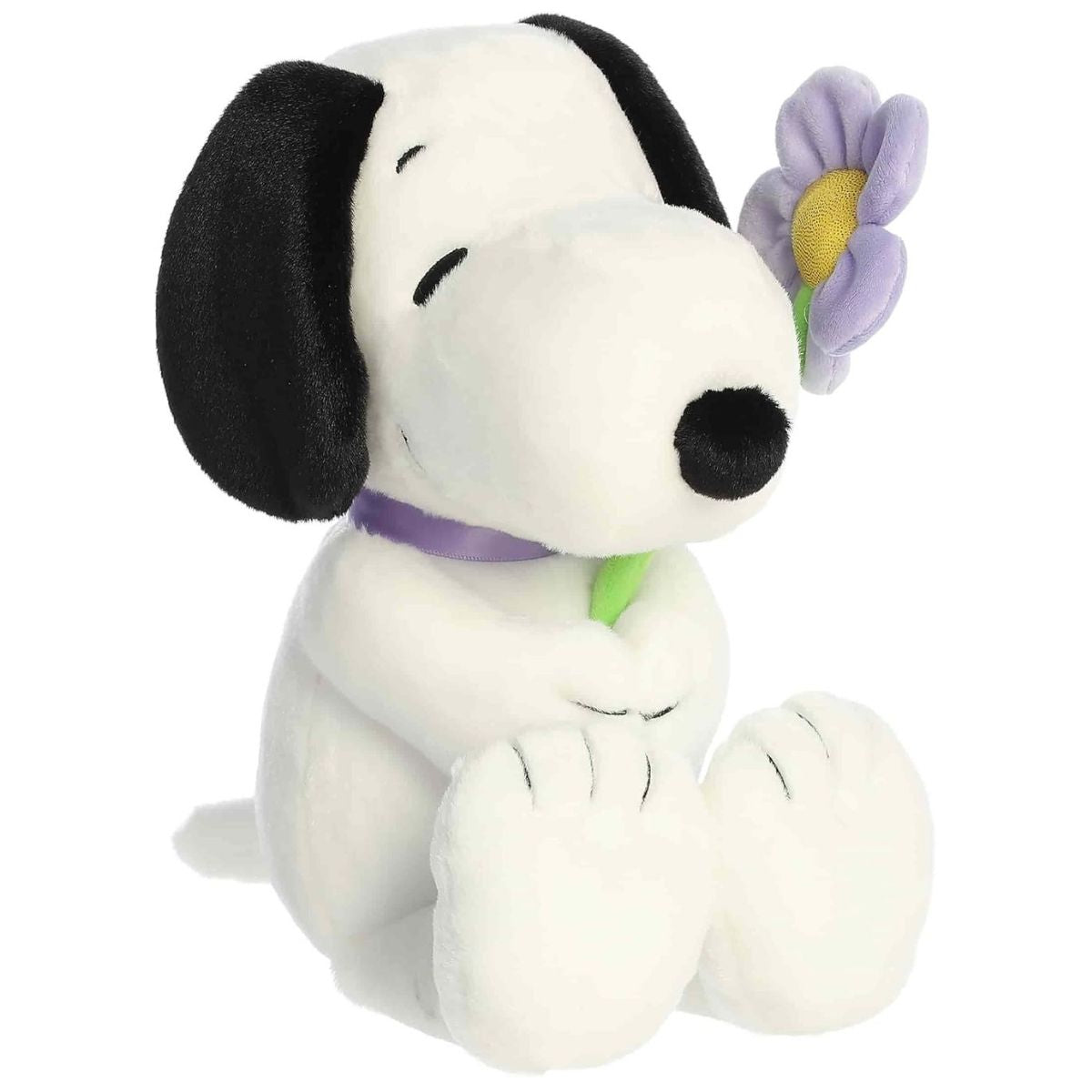 Slightly angled front right view of the cuddly Snoopy plush sitting comfortably with his flower.