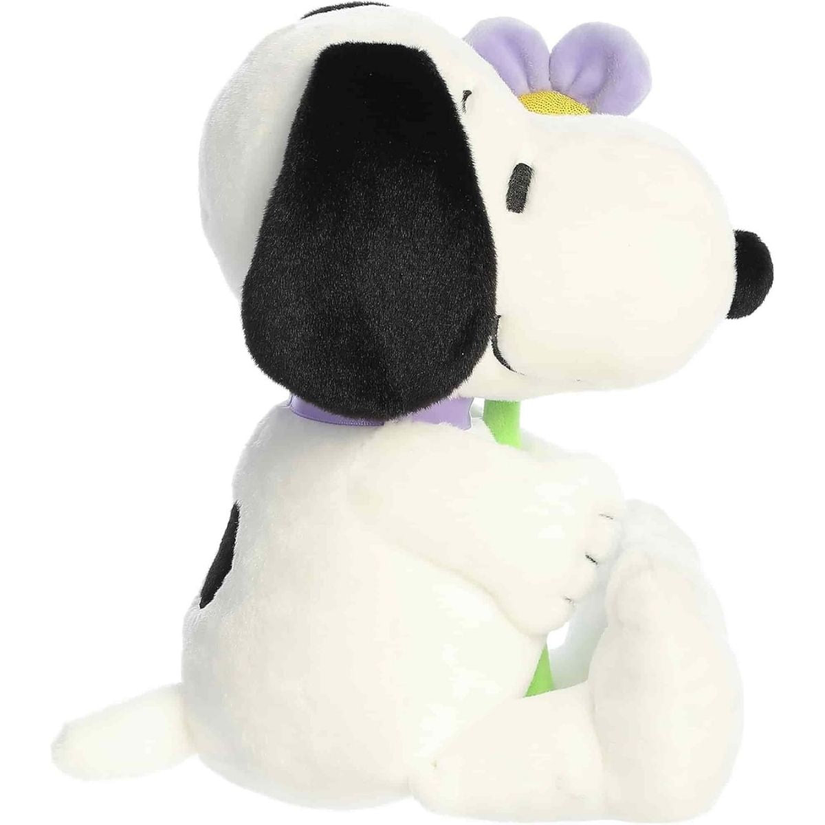 Side profile view of the Aurora Peanuts Snoopy plush sitting with his legs extended.