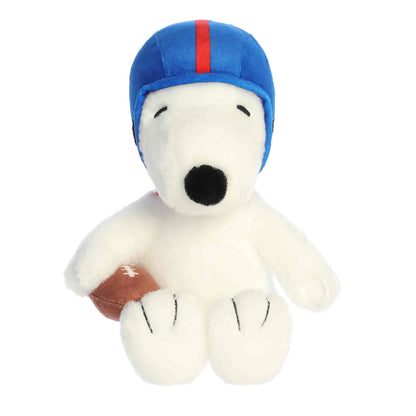 Straight front view of the sitting Snoopy stuffed animal showing his blue and red helmet, black nose, and brown football.