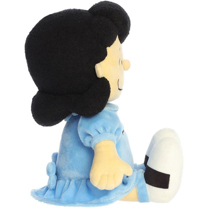 Side profile view of the Aurora Peanuts Lucy plush sitting with her legs extended.
