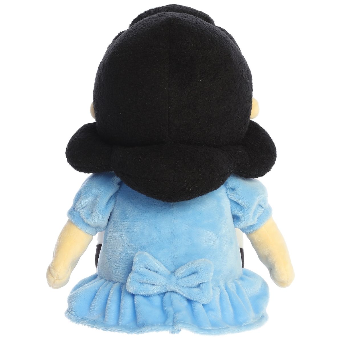 Direct back view of the cuddly Lucy stuffed animal sitting down, highlighting the blue bow on the back of her dress.