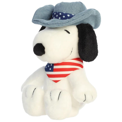 Aurora 8-inch Peanuts Americana Snoopy plush toy sitting forward wearing a denim-look hat with stars and a red, white, and blue striped bandana.